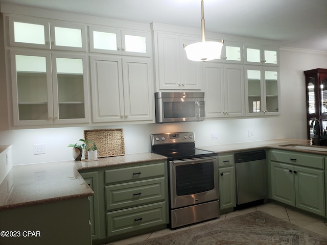 kitchen with pendant lighting, white cabinets, sink, light tile patterned floors, and stainless steel appliances