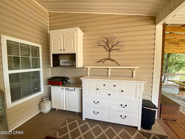 kitchen with white cabinetry and wooden walls