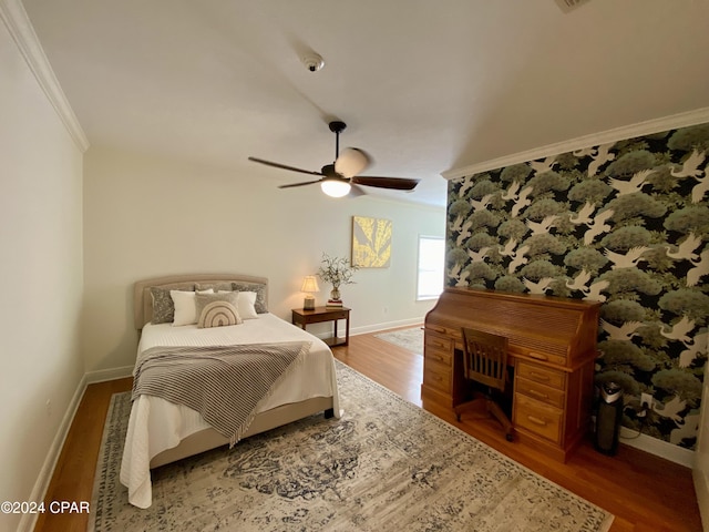 bedroom featuring hardwood / wood-style floors, ceiling fan, and crown molding