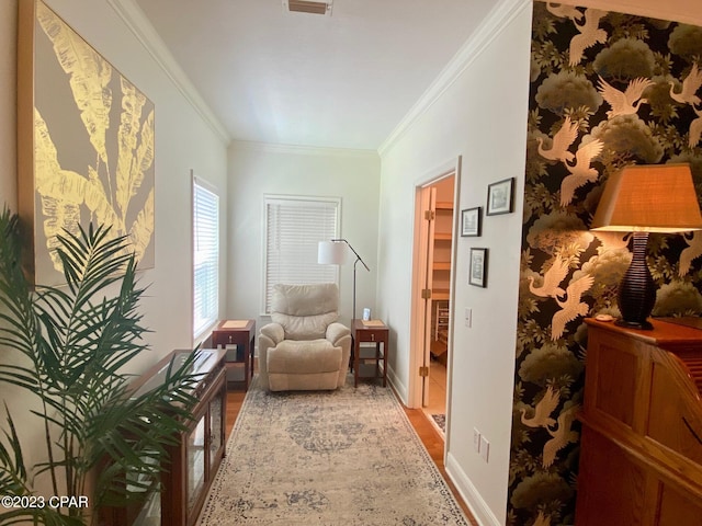 sitting room with wood-type flooring and ornamental molding