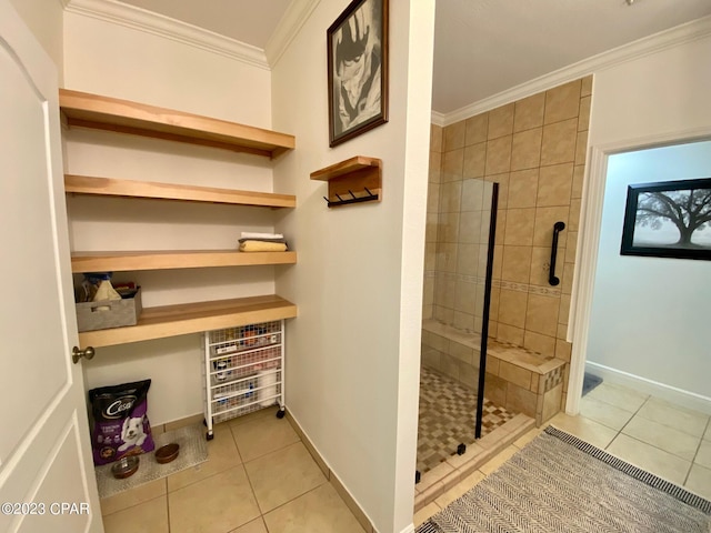 bathroom featuring tile patterned flooring, a tile shower, and crown molding