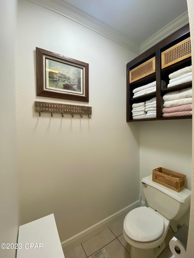 bathroom with tile patterned floors, toilet, and crown molding