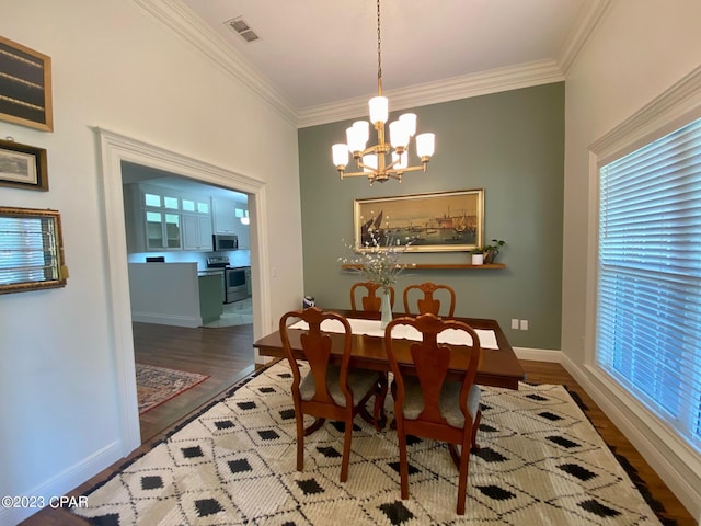 dining area featuring wood-type flooring, crown molding, and a chandelier