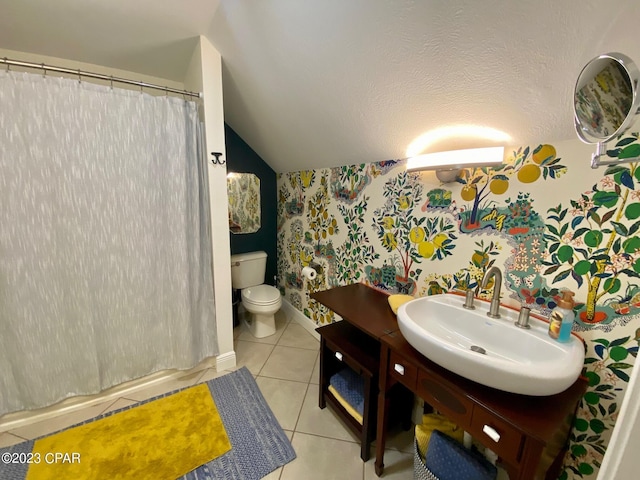 bathroom with tile patterned flooring, vanity, toilet, and lofted ceiling