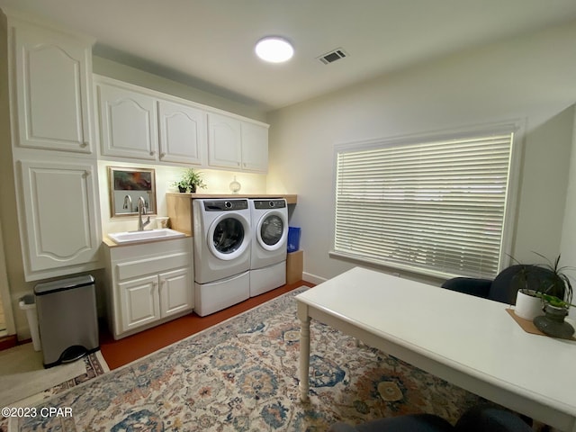 laundry area with washer and dryer, cabinets, and sink