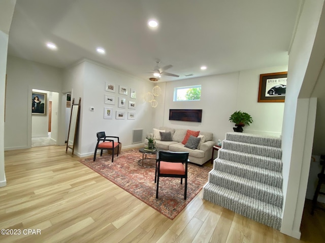 living room with ceiling fan and light hardwood / wood-style floors