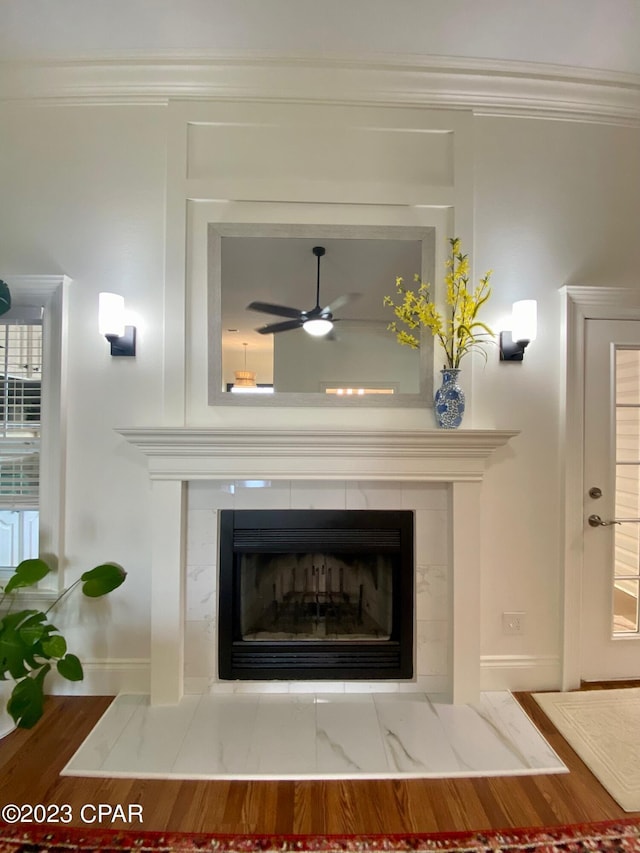 room details featuring a tile fireplace, ceiling fan, and ornamental molding