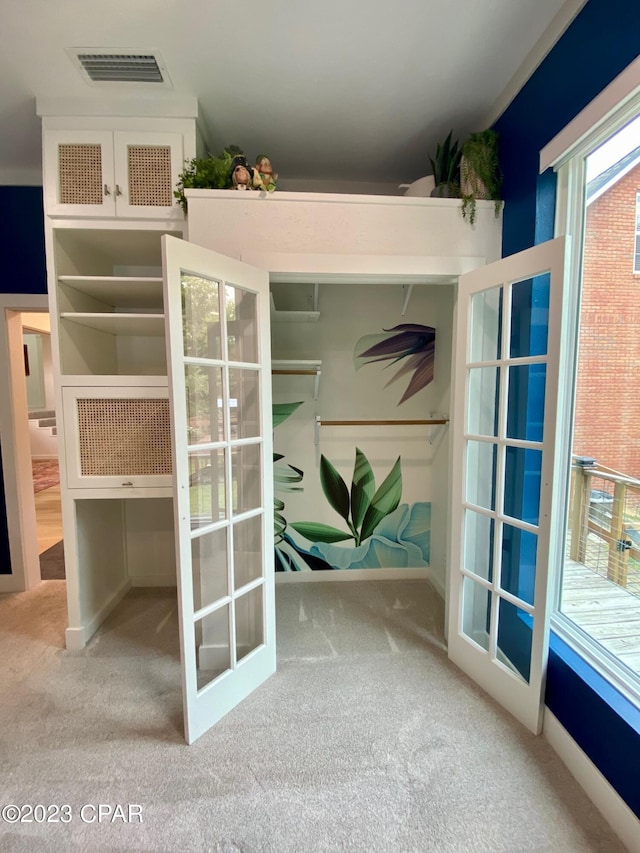 interior space with light carpet and french doors