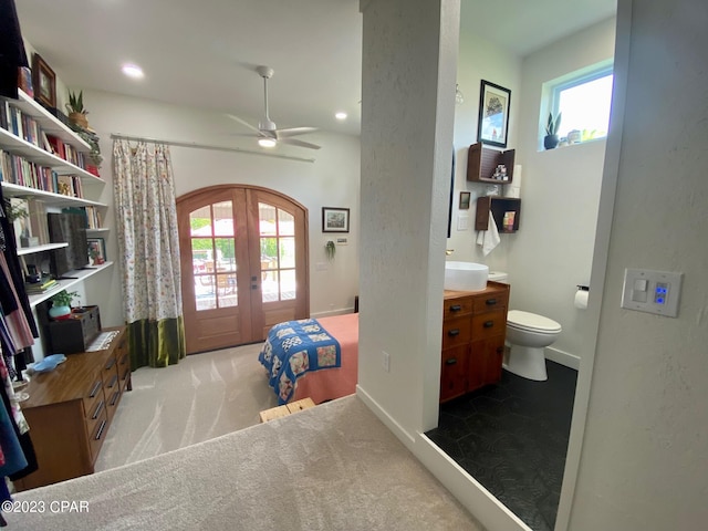 bedroom featuring french doors, light colored carpet, multiple windows, and ceiling fan