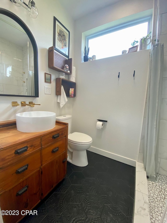 bathroom with plenty of natural light, curtained shower, toilet, and vanity