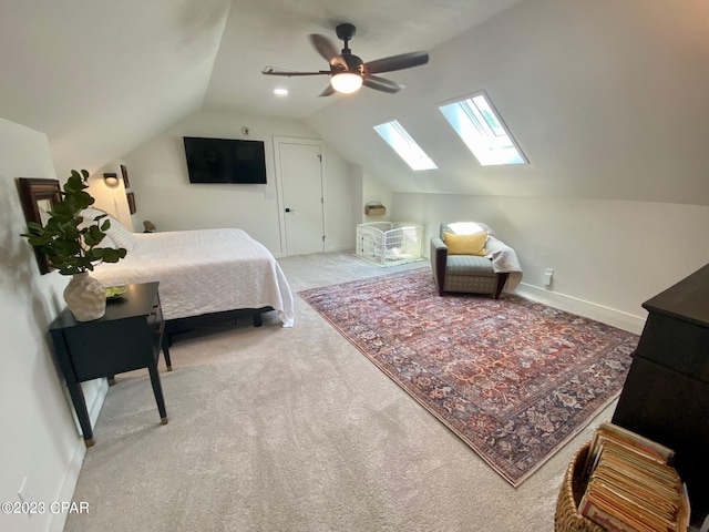 carpeted bedroom with lofted ceiling with skylight and ceiling fan