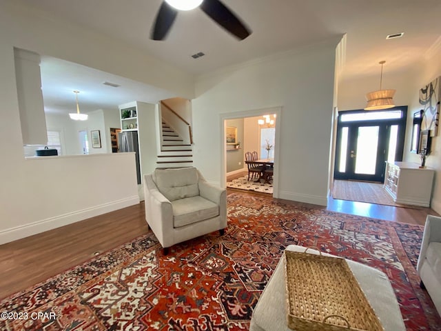 living room with crown molding, ceiling fan, and dark hardwood / wood-style floors