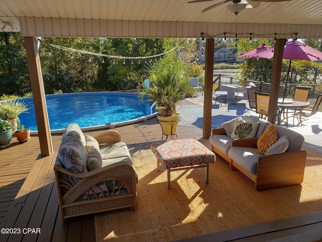 view of pool featuring ceiling fan, a deck, and an outdoor hangout area