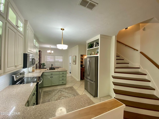 kitchen with white cabinetry, a chandelier, decorative light fixtures, light tile patterned floors, and appliances with stainless steel finishes