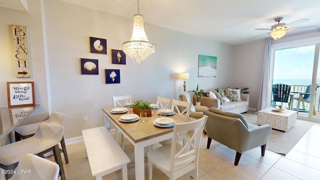 tiled dining area with ceiling fan with notable chandelier