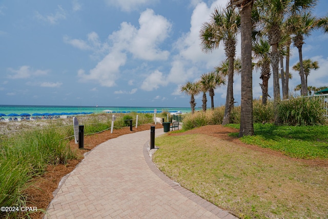 view of home's community featuring a view of the beach, a yard, and a water view