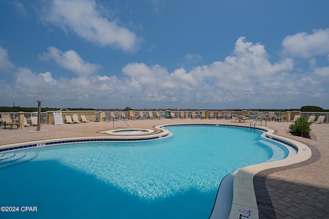 view of pool with a hot tub and a patio area