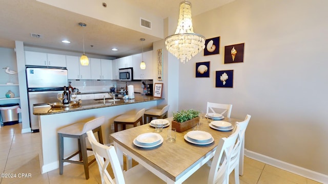 dining room featuring a chandelier, sink, and light tile patterned floors