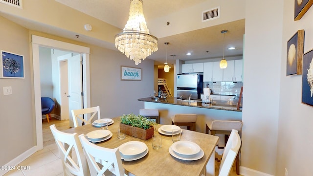 dining area featuring a notable chandelier and light tile patterned floors