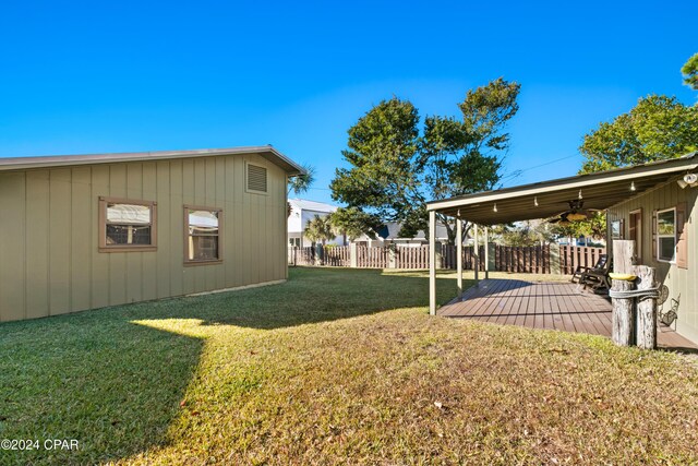 view of yard featuring a deck and ceiling fan