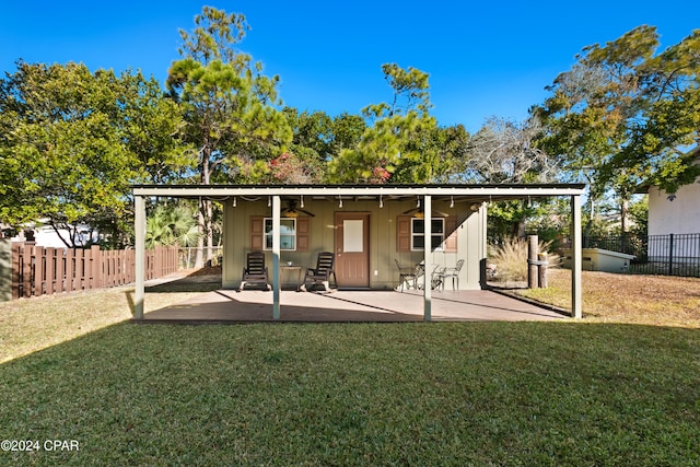 rear view of property with a lawn, ceiling fan, and a patio area