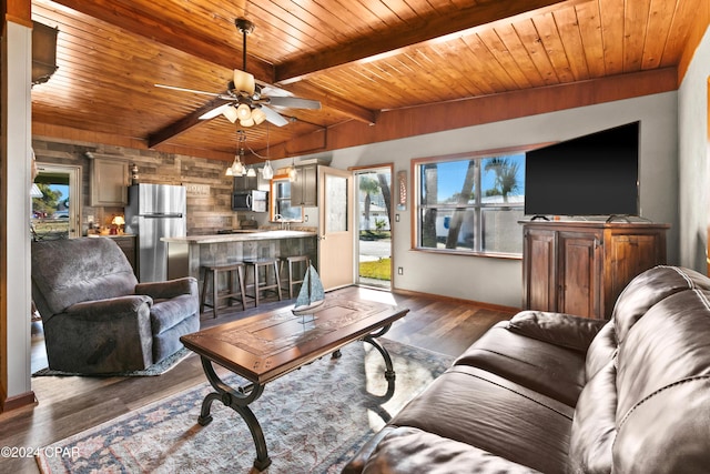 living room featuring beamed ceiling, dark hardwood / wood-style floors, ceiling fan, and wood ceiling