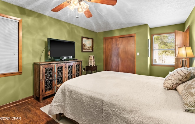 bedroom featuring a closet, a textured ceiling, dark hardwood / wood-style floors, and ceiling fan