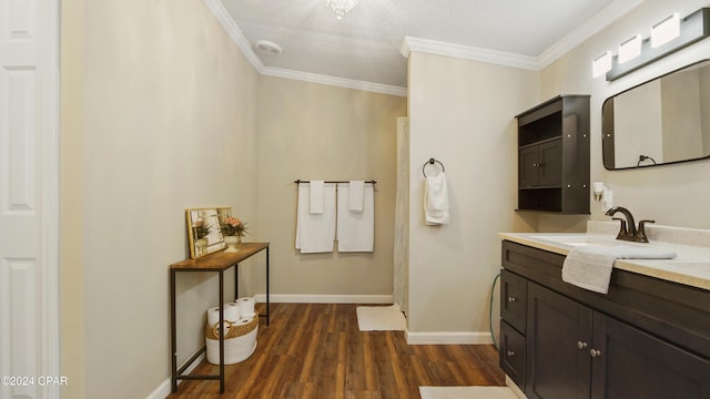 bathroom with wood-type flooring, vanity, and crown molding