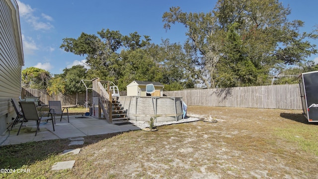 view of yard with a storage shed and a patio