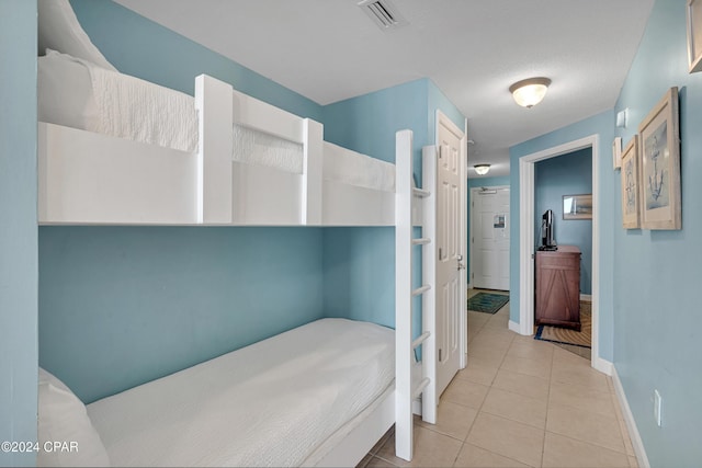 tiled bedroom with a textured ceiling