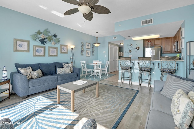 living room with ceiling fan and light hardwood / wood-style floors