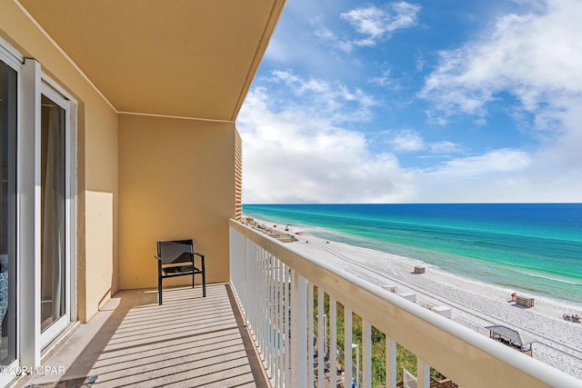 balcony with a water view and a view of the beach