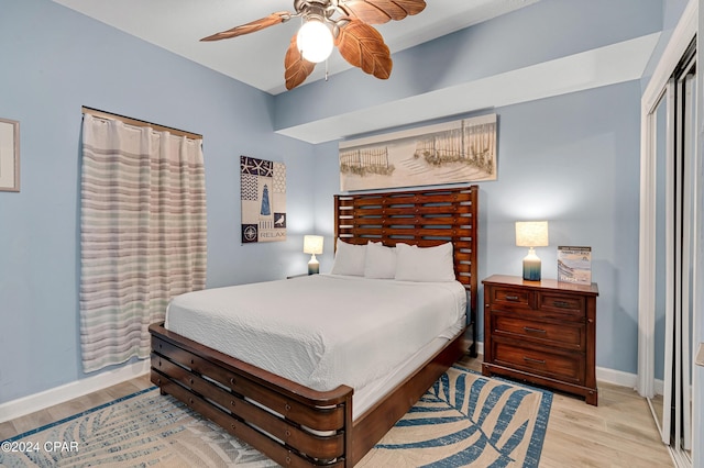 bedroom featuring ceiling fan, a closet, and light wood-type flooring