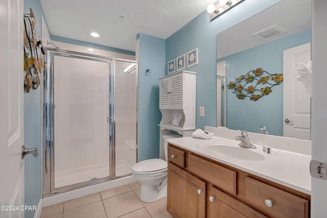 bathroom featuring a shower with shower door, vanity, tile patterned flooring, and toilet