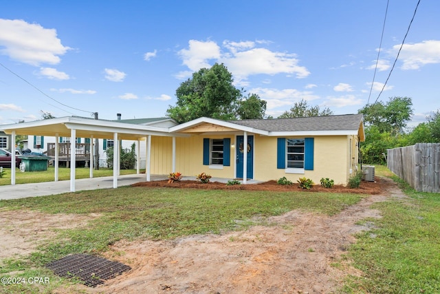 view of front of property featuring a front yard, cooling unit, and a carport