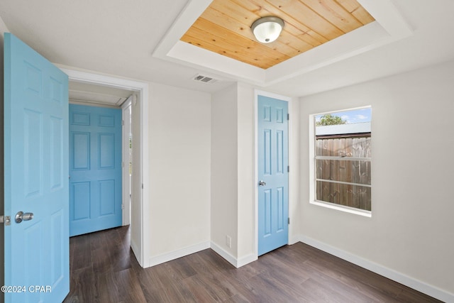 interior space with wood ceiling, dark wood-type flooring, and a tray ceiling