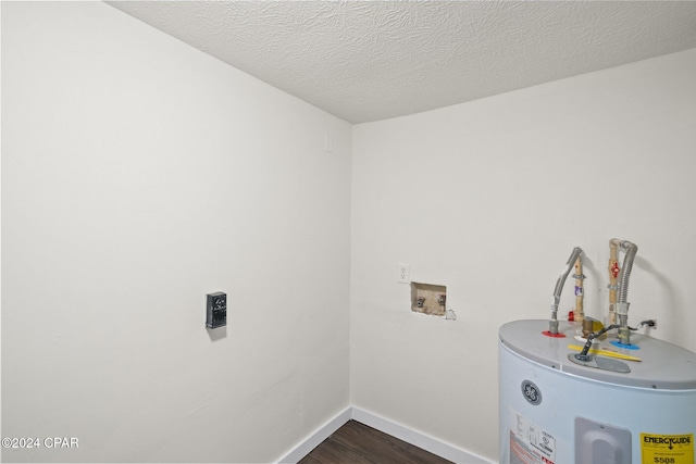 washroom with water heater, dark hardwood / wood-style flooring, hookup for a washing machine, and a textured ceiling