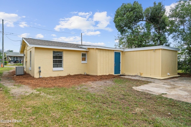 rear view of property featuring a patio and a yard