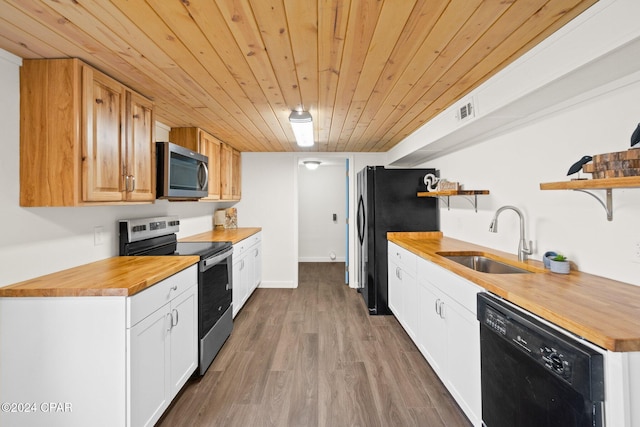 kitchen with butcher block counters, wooden ceiling, sink, black appliances, and hardwood / wood-style floors