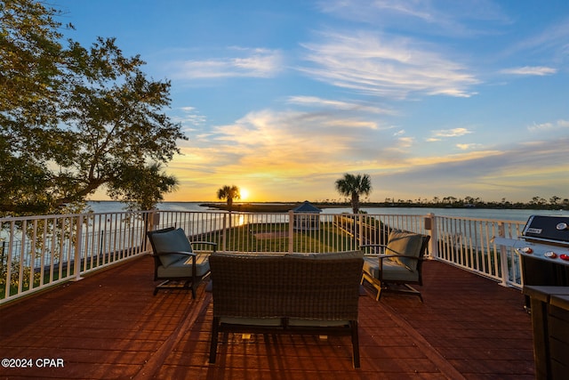 patio terrace at dusk with an outdoor hangout area and a water view