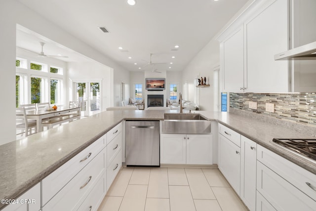 kitchen featuring stainless steel appliances, white cabinetry, sink, tasteful backsplash, and light stone countertops