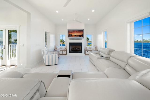 living room with lofted ceiling, light tile patterned floors, and ceiling fan