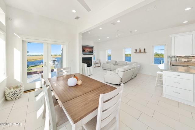 tiled dining area featuring ceiling fan and french doors