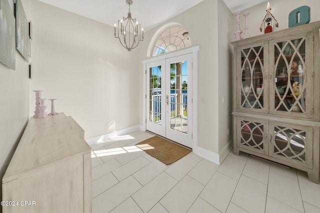 foyer featuring vaulted ceiling, a chandelier, light tile patterned floors, and french doors