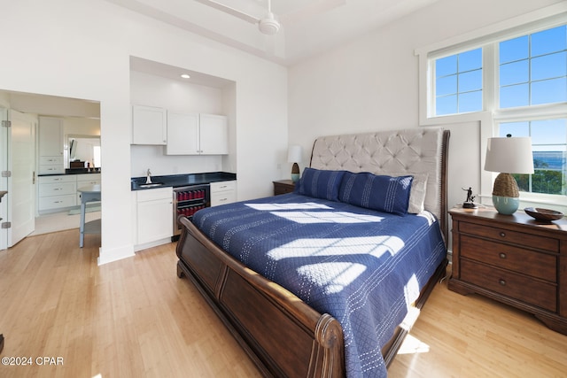 bedroom with ceiling fan, multiple windows, and light hardwood / wood-style flooring