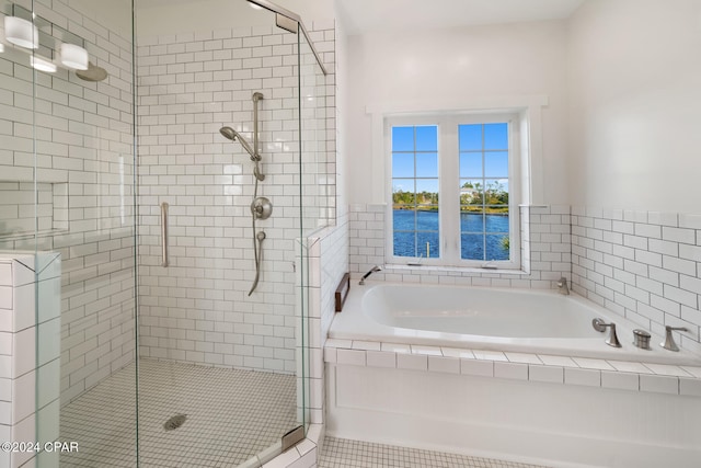 bathroom with tile patterned flooring, shower with separate bathtub, and a water view