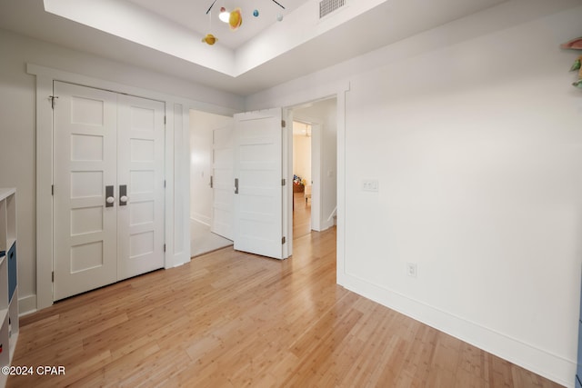 unfurnished bedroom with a closet and light hardwood / wood-style floors