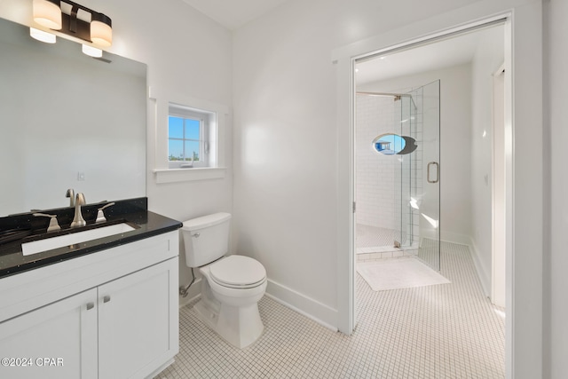 bathroom with tile patterned flooring, vanity, a shower with door, and toilet