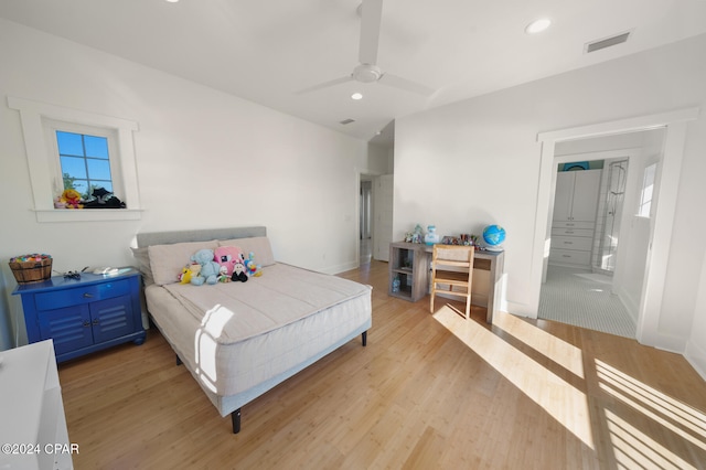 bedroom featuring ceiling fan, connected bathroom, and light wood-type flooring