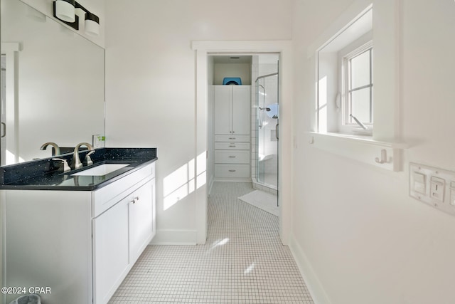 bathroom featuring tile patterned flooring, vanity, and a shower with door